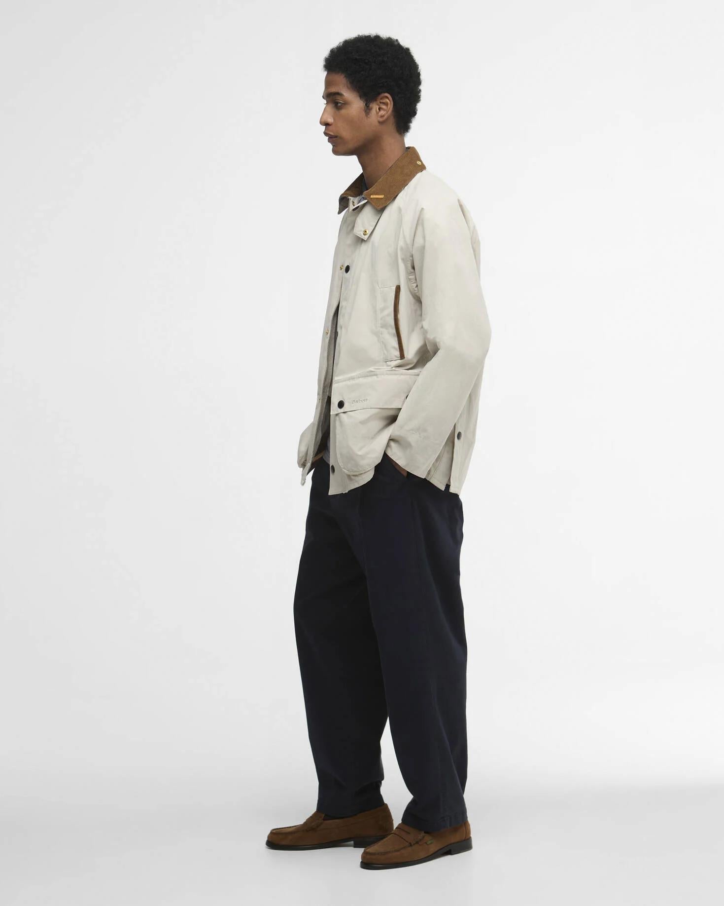 Nærbilde som viser jakken med kordkrage, trykknapper og store frontlommer.