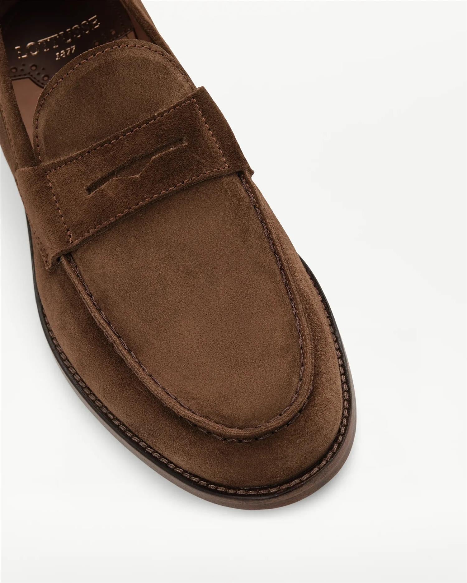 Detaljbilde av brune semsket Lottusse loafers som viser penny-strap, håndsydde sømmer og struktur i kalveskinn.