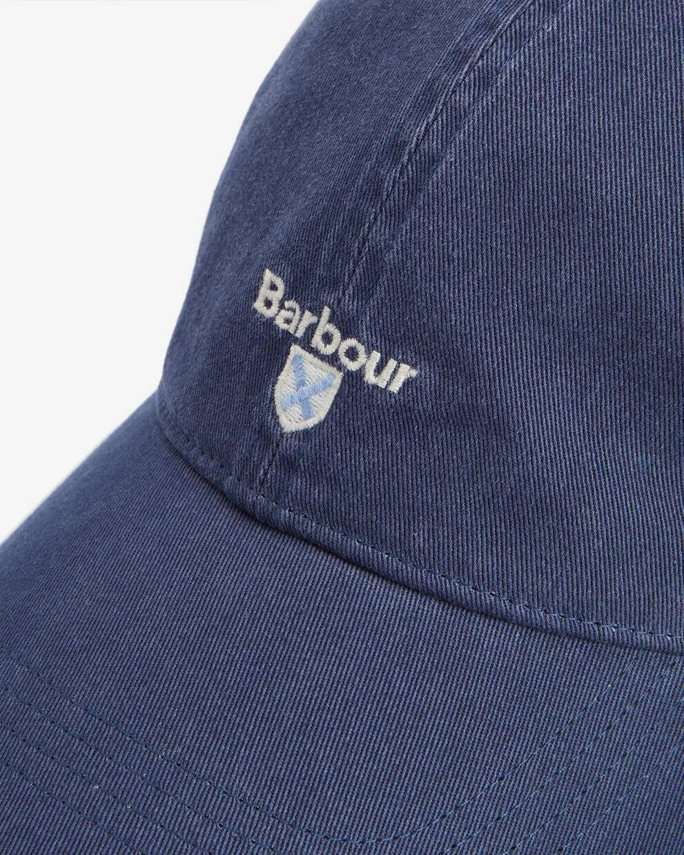 Nærbilde av Barbour logo og våpenskjold under. Plassering rett over brem
