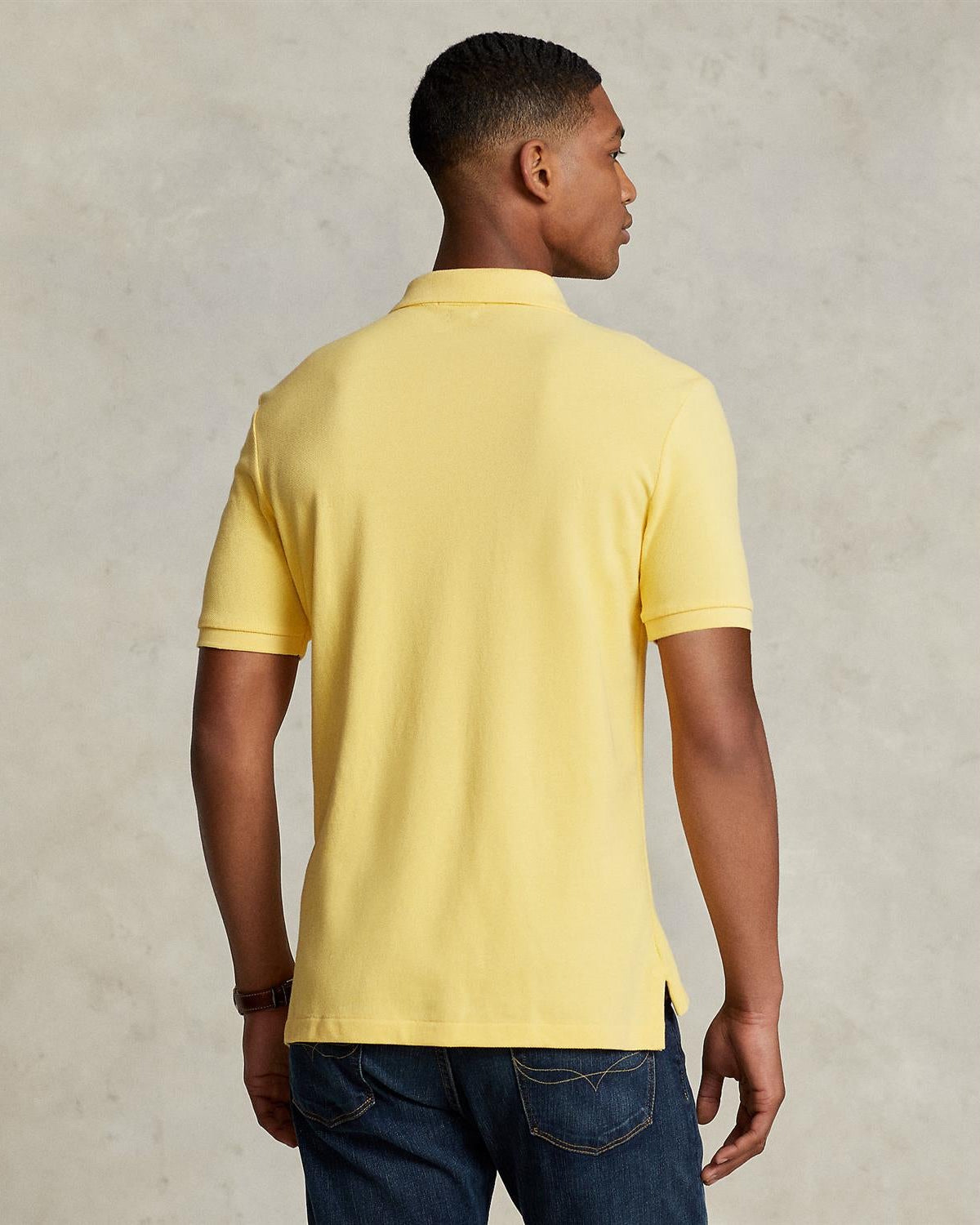 Halvfigur fra baksiden, modell med plagget på sammen med en bukse