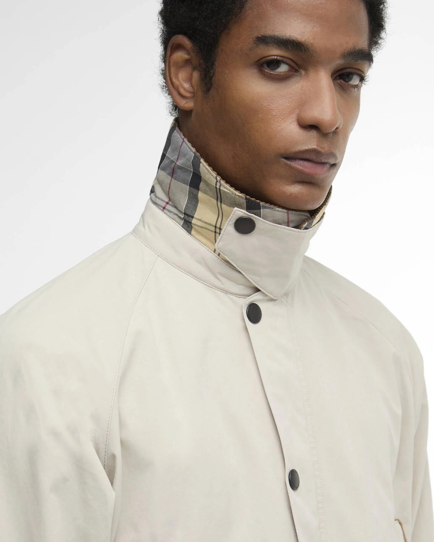 Detaljbilde av nedre del av Barbour Bedale jakke som viser brystlommer, trykknapper og Jetlomme med korddetalj