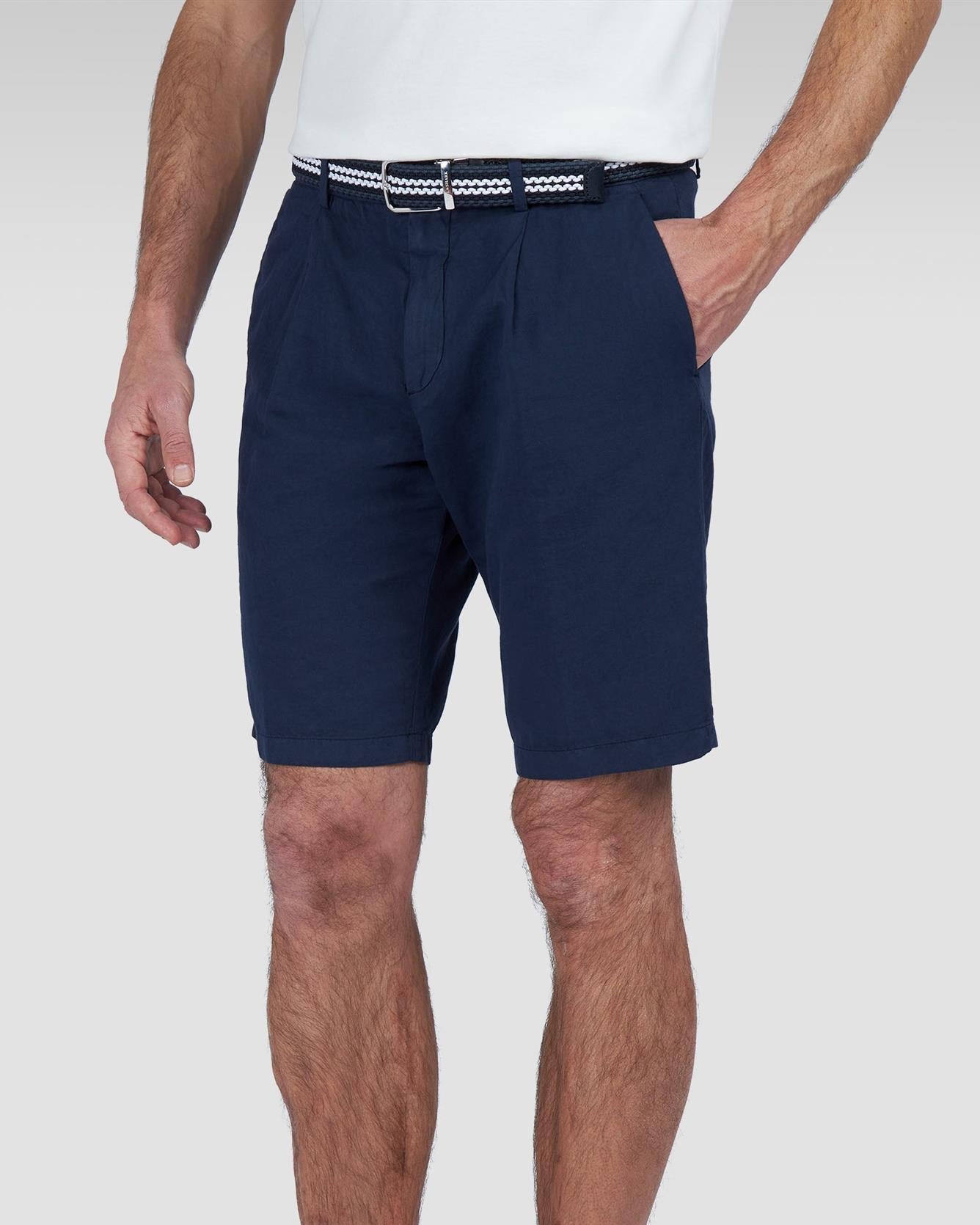 Modell med Shortsen på sett forfra, viser frontfold, skrålommer og klassisk lengde til over kneet