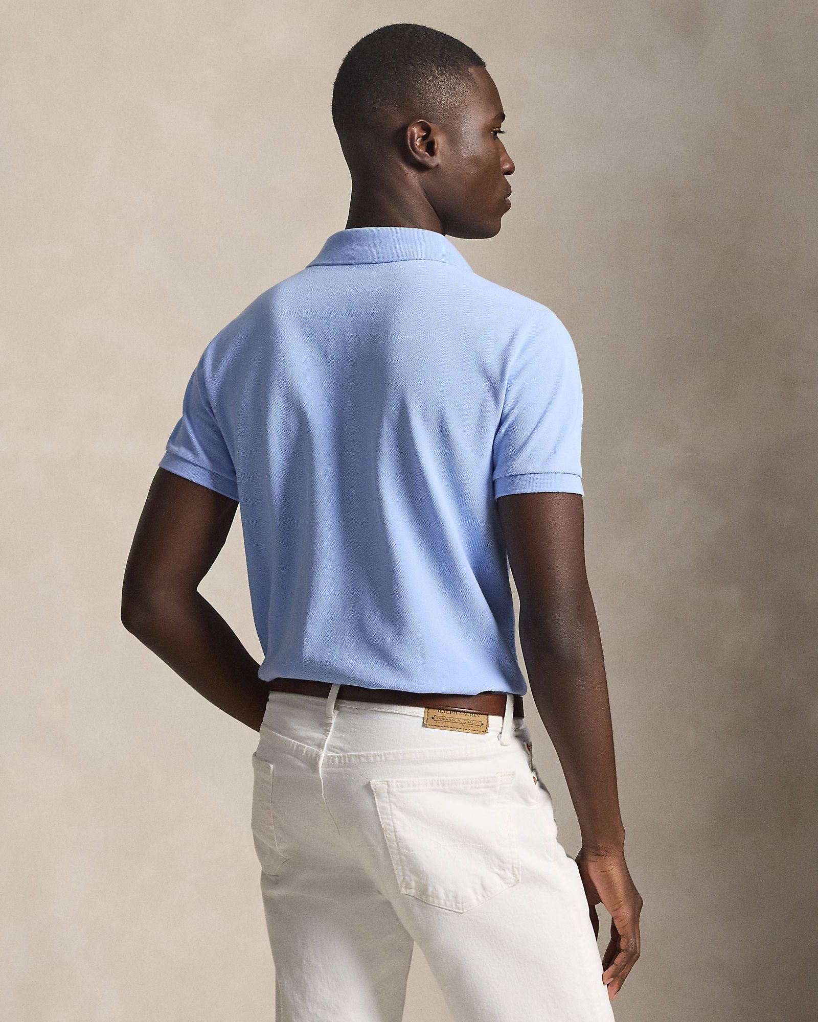 Halvfigur fra baksiden, modell med plagget på sammen med en bukse