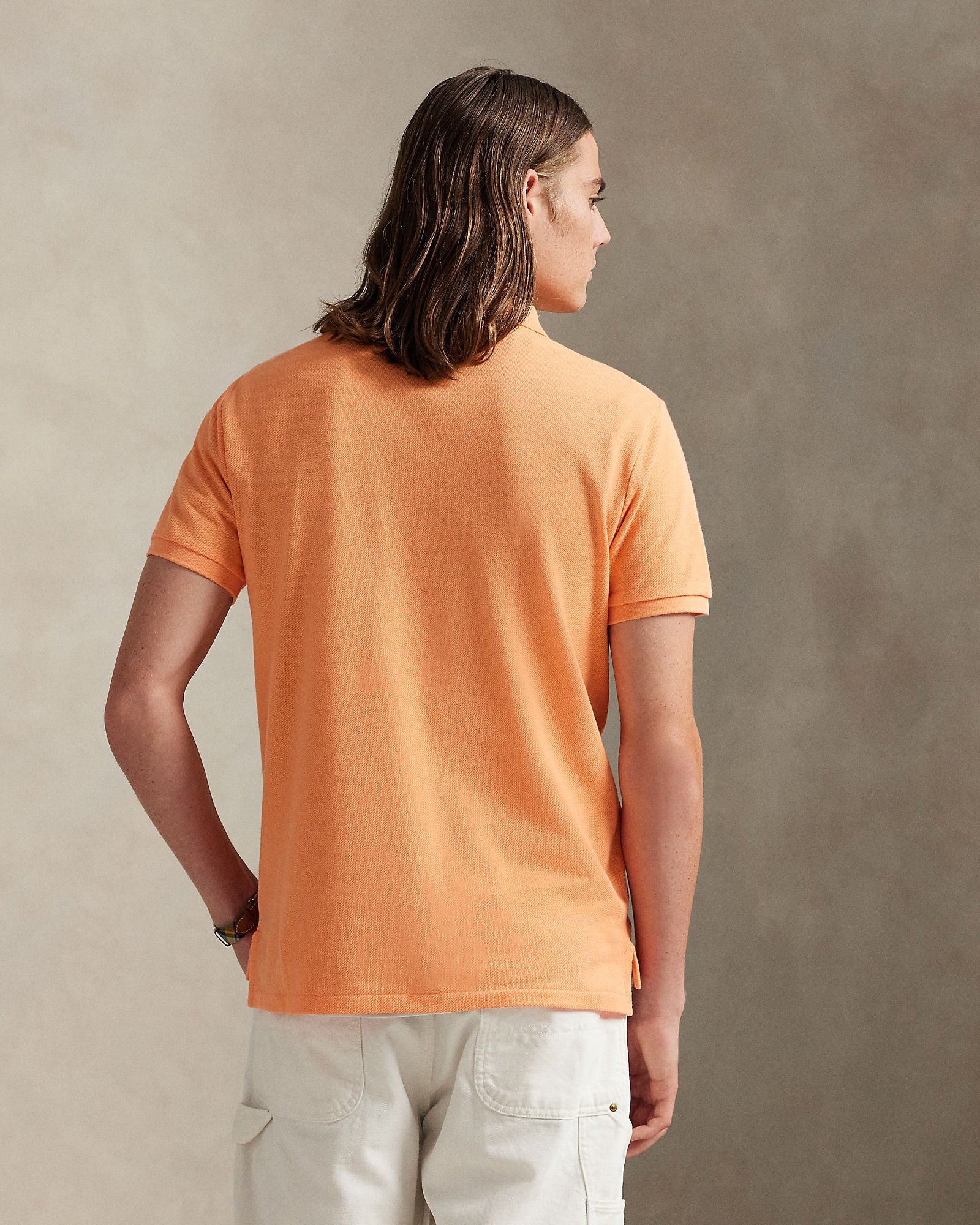 Halvfigur fra baksiden, modell med plagget på sammen med en bukse