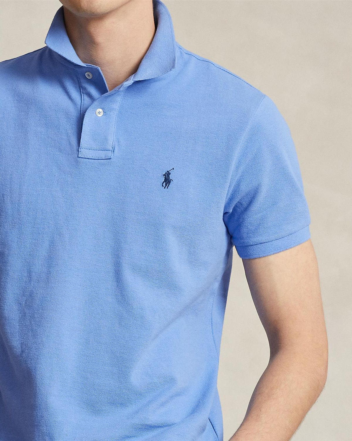 Nærbilde av pique, viser brystpartiet og logo